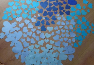 Duże serce ułożone z małych serduszek o różnych odcieniach niebieskiego.